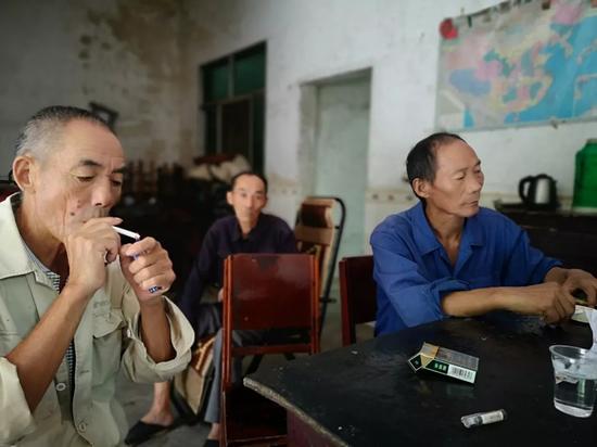 云南“反杀”案:致命相遇 王关平的父亲王明方(右一)与王关平的两个伯父(右二、右三)。新京报记者段睿超 摄