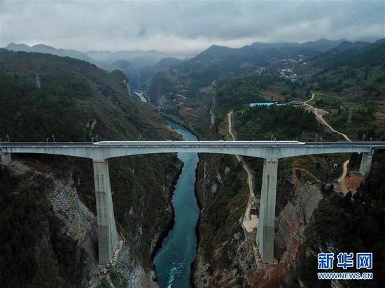一列从贵阳北到重庆西的动车行驶在贵州省遵义市境内的乌江大桥上（1月25日无人机拍摄）。新华社记者 刘续 摄