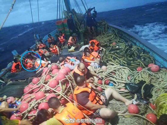 幸存者们在救援渔船上，回程途中天色渐黑。蓝圈中是龙儿。