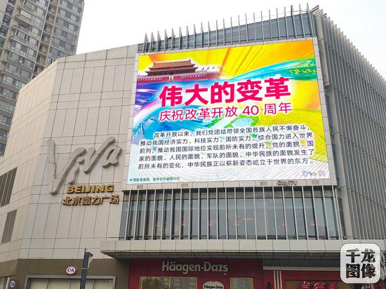 12月2日，“伟大的变革——庆祝改革开放40周年”宣传挂图亮相北京街头，为庆祝改革开放40周年营造热烈氛围。图为北京市双井附近的大屏幕。千龙网发
