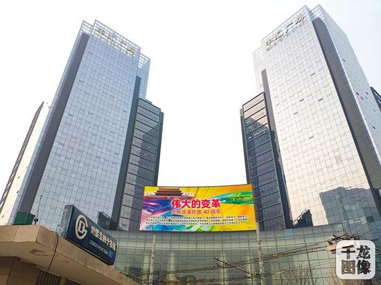 12月2日，“伟大的变革——庆祝改革开放40周年”宣传挂图亮相北京街头，为庆祝改革开放40周年营造热烈氛围。图为北京市东四十条附近的大屏幕。千龙网发