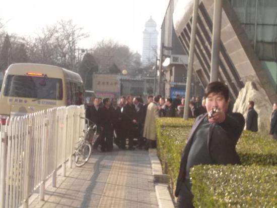 圖中穿黃色風衣者為劉士余
