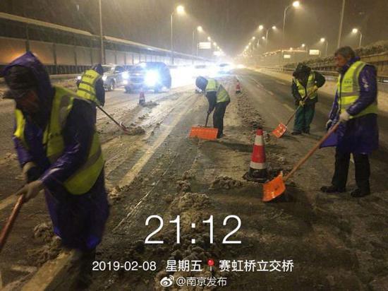 2月8日深夜，江苏南京赛虹桥立交桥，工作人员在清理道路积雪。  @南京发布 图