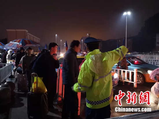 2月13日，柳州市交通综合行政执法队工作人员在火车站前疏导乘客打车。