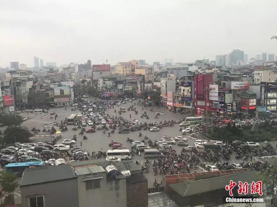 2月25日，越南首都河内，第二次朝美领导人会晤举行前，河内街头民众正常出行，摩托为当地主要出行方式之一。正值下班高峰期，大量摩托车在路口准备过路。中新网记者孟湘君 摄