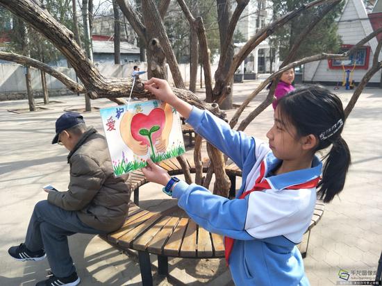 学雷锋活动日:学雷锋纪念日 北京在行动 朝师附小绘制标语牌美化社区。学校供图。