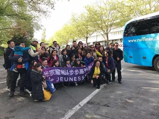 ▲婕斯公司组织的中国经销商旅游团，拿着“光宗耀祖&amp；步步高升”的横幅合影。  图片来源/ 20 Minuten