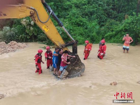 6月16日，因遭遇暴雨袭击，广西沿海多处发生严重内涝，居民被困。当地消防部门接到求助信息后，先后转移被困的居民数十人。图为利用铲车运送被困居民。