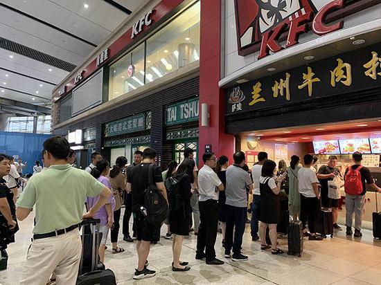 京沪高铁晚点:京沪高铁沿线列车晚点:部分旅客滞留北京南站 肯德基门口购买食物的长队。图片拍摄:唐俊