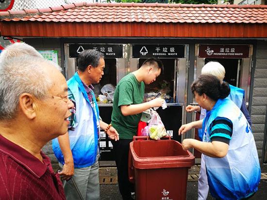 曲阳街道志愿者正在帮居民垃圾分类。