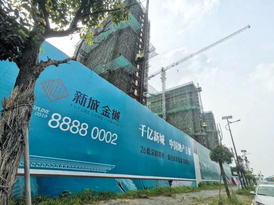 ▲7月6日,新城金樾项目外的围墙上,“千亿新城中国地产8强”的广告。