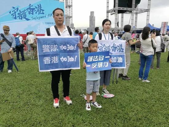  20日下午，在添马公园内，也有集会参与者提前一个小时到场，手举“护法治，反暴力”、“警队加油，香港加油”等标语。图源：大公文汇新媒体