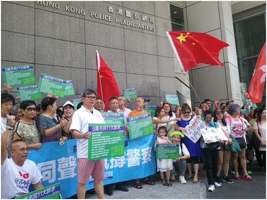 8日中午，数十名香港市民自发前往湾仔香港警察总部，高举五星红旗和撑警标语，声援警方。图片来源：大公文汇全媒体