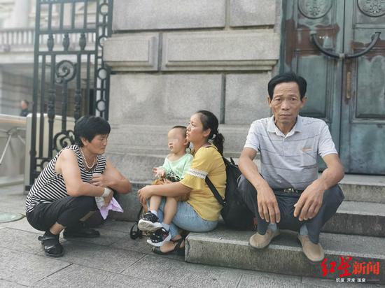 　↑8月14日上午，王凤雅家人在法院外等待开庭