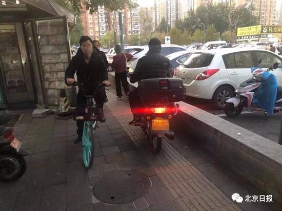  广渠路一家乐福超市门前京B号牌摩托车便道行驶。