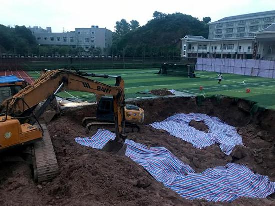  6月19日，在新晃一中操场的跑道上被挖出的深坑。澎湃新闻记者 蒋格伟 图 