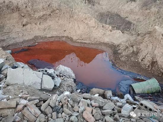  ▲2019 年 12 月 12 日，山东省郓城县西营窑厂复垦项目的土坑中，铁桶浸泡在褐色污水里，现场气味刺鼻。当地填埋负责人称，铁桶装有液体危废。新京报记者 王飞 摄
