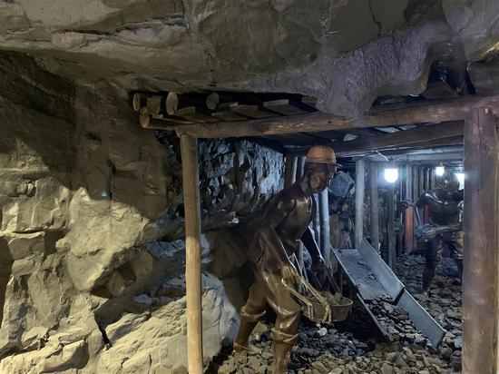 　▲鹤岗市博物馆里介绍“地下宝藏”的专区里，还原煤炭工人工作场景的铜像。