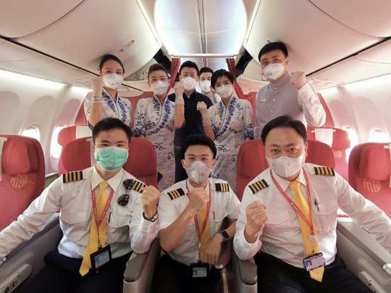 2月15日,海南航空第4架包机护送医疗队,机组人员为医疗队添油打气。