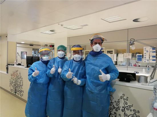 3月18日，在意大利帕多瓦，中国抗疫医疗专家组成员与当地医生合影。新华社发（中国抗疫医疗专家组供图）