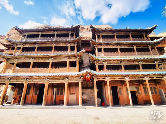 △第5、6窟是工程浩大、雕饰华丽的典型洞窟。窟前四层木质楼阁为清顺治八年（1651年）所建。第5窟主像是云冈石窟第一大佛，坐佛高17米。（总台央视记者李辉、杨波拍摄）