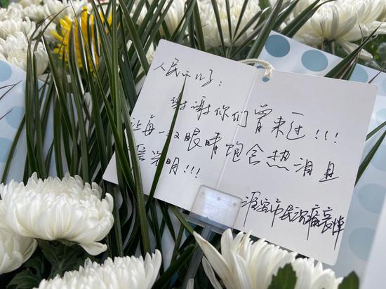 一名淮安市民送别两人,献上的鲜花中有一张卡片,写到:“谢谢你们曾经来过,让每一双眼睛饱含热泪且相信光明。”