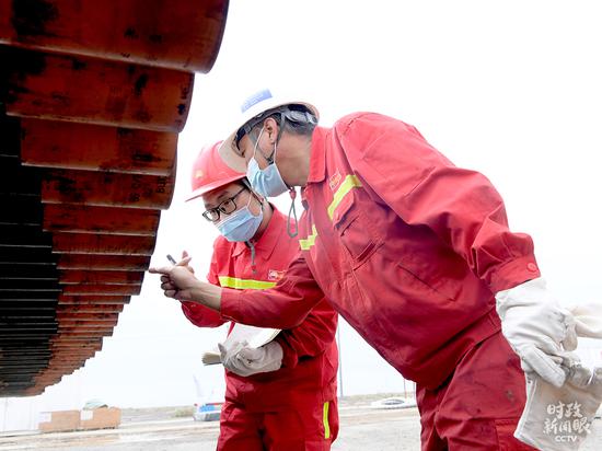 △中国石油大学（北京）克拉玛依校区2020届毕业生王首都（左）在克拉玛依钻井一线工作。