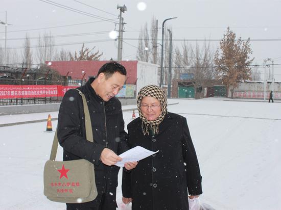  ▲  2017年12月，新疆博乐市小营盘镇的“书包干部”在走访村民。