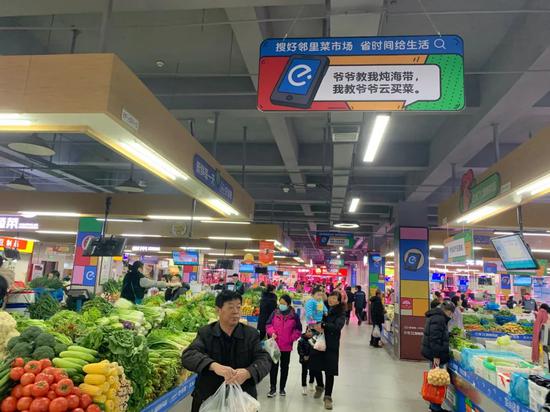  12月15日，记者来到南京尧化门好邻里惠民菜市场，这家经过数字化改造的菜市场，四处悬挂着“云买菜”的宣传条幅。本报记者潘晔摄