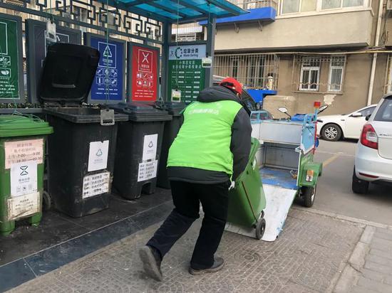 ▲厨余垃圾桶满后，将桶拖走，再放置一个空桶在原来位置上。新京报记者 张静姝 摄