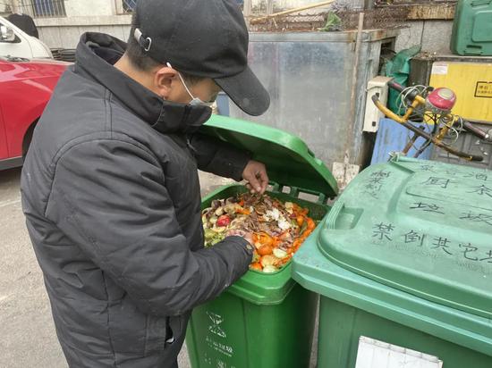  ▲王泽生挑出混在厨余垃圾里的易拉罐拉环。新京报记者 周思雅 摄