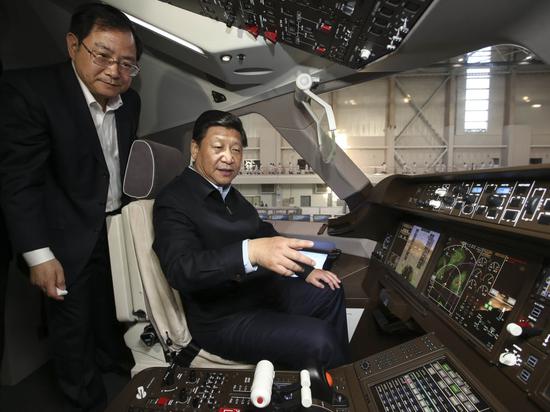↑2014年5月23日至24日,习近平在上海考察调研。这是23日下午,习近平在中国商飞设计研发中心C919大型客机展示样机驾驶室察看。