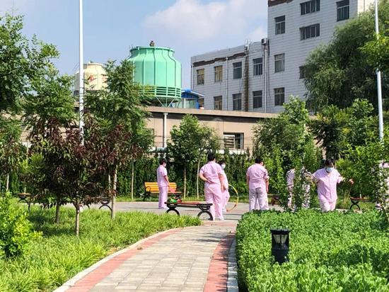 女性受助者在医院后花园做游戏。新京报记者 冯雨昕 摄