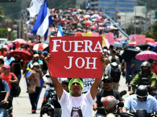 ·举着“JOH（胡安·埃尔南德斯名字缩写）滚蛋”标语的洪都拉斯抗议者。