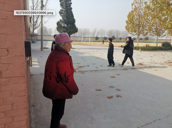 11月26日中午，一位学生家属在戚城中学校园内，正等待自己的孙女。她骑着电动三轮车专门过来送饭。蒋政/摄影