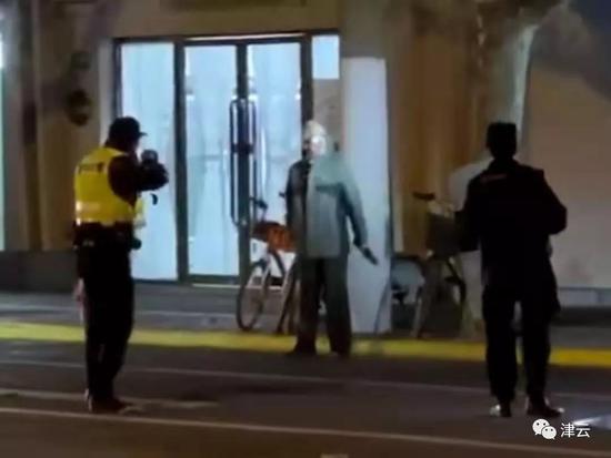  戴头套的嫌疑人周某与民警在红宝石店面门口对峙