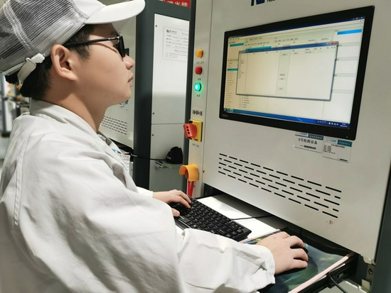 7月20日，在广州广汽埃安新能源汽车有限公司动力电池车间，电池支持工程师周林在调试动力电池检测设备。新华社发