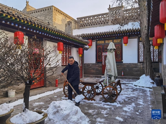 平遥居民范东山在自家的四合院里清理积雪（1月25日摄）。新华社记者 王学涛 摄