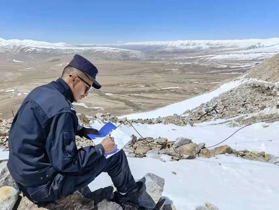 移民管理警察索朗曲扎在典角村绘制地形图。（受访者提供）