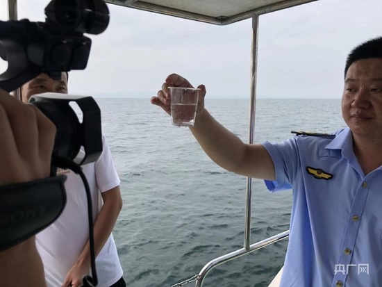 淅川县丹江库区综合执法人员向记者展示丹江水质（央广网发 张惟一 摄）