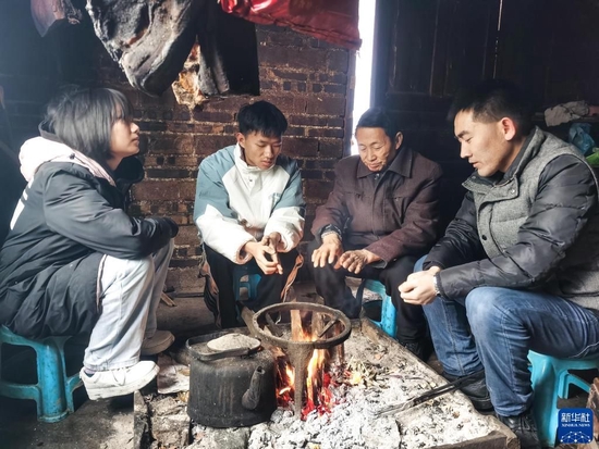 贵州省望谟县实验高中党总支副书记、副校长刘秀祥（右一）在学生家中家访（2022年2月1日摄）。新华社发