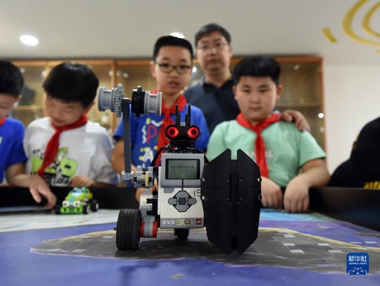 在合肥市和平小学，信息技术老师杨森（右二）在“课后三点半”时间指导机器人社团的学生（2021年9月8日摄）。新华社记者 周牧 摄