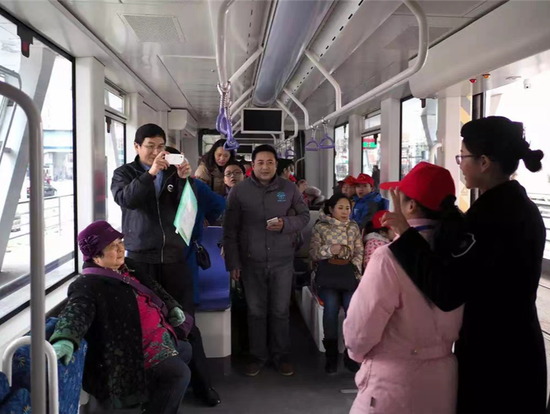  2015年12月19日淮安现代有轨电车首次载客，乘客争相合影留念（央广网发 贺敬华 摄）