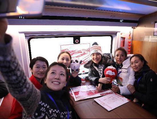  图为北京冬奥组委运动员委员会委员陈露（右一） 北京冬奥组委运动员委员会委员刘显英（右二） 国际奥委会委员、奥运冠军张虹（右三） 中国奥委会委员、原中国国家短道速滑队主教练李琰（左三） 中国女子跆拳道运动员、奥运冠军吴静钰（左一） 北京冬奥会和冬残奥会运动员委员会主席、奥运冠军杨扬（左前） 在G8811次列车上合影。 中新社记者 蒋启明 摄