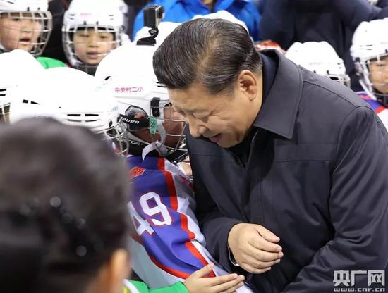 △2017年2月24日，习近平在北京五棵松体育中心观看青少年冰球训练，与一位小冰球队员肩碰肩