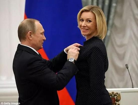 普京为扎哈罗娃佩戴友谊勋章。