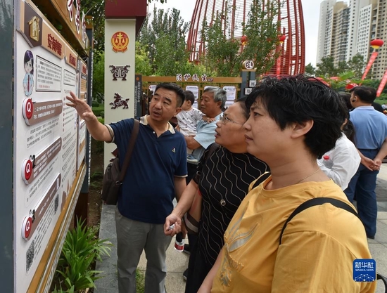 在天津市津南区海河故道公园民法典主题长廊，市民在讨论主题长廊展板上的法律案例（2020年8月20日摄）。新华社记者 孙凡越 摄