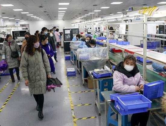 2月27日,秀山县工业园区一家电子企业生产车间,求职者参观了解工作岗位情况。(新华社)