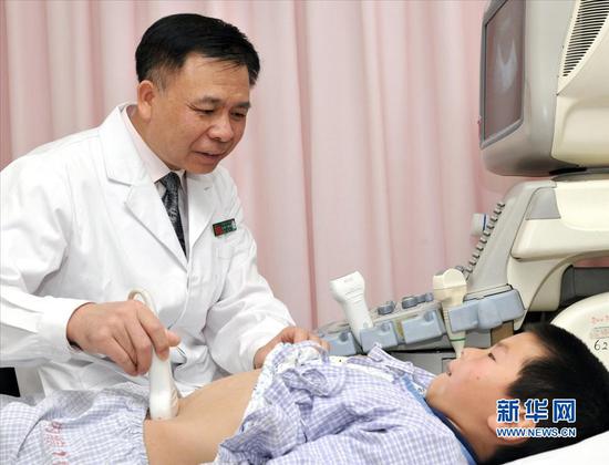贾立群正在为患儿做B超检查。（资料图片）