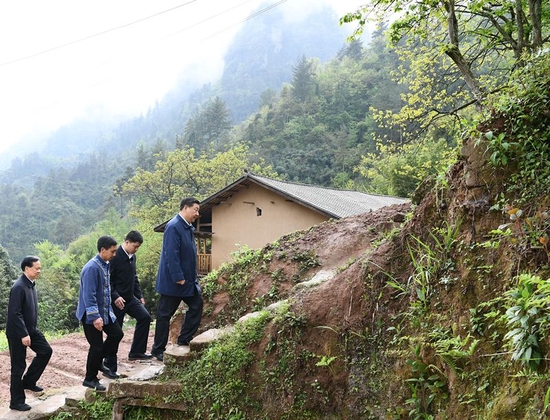 2019年4月15日，在重庆市石柱土家族自治县中益乡华溪村，习近平踏着湿滑的石阶登上陡坡，前往贫困户谭登周家看望。